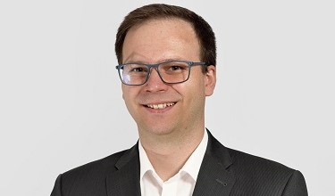 Laechelnder Mann im schwarzen Anzug