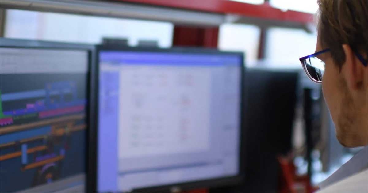 Mann betrachtet zwei Computerbildschirme