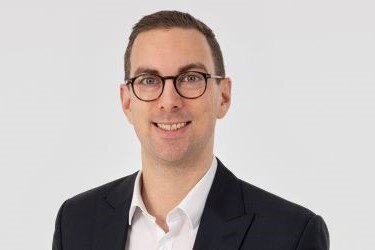 Laechelnder Mann im schwarzen Anzug