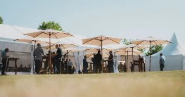 Personen stehen unter Sonnenschirmen bei den BCT Technology Tagen