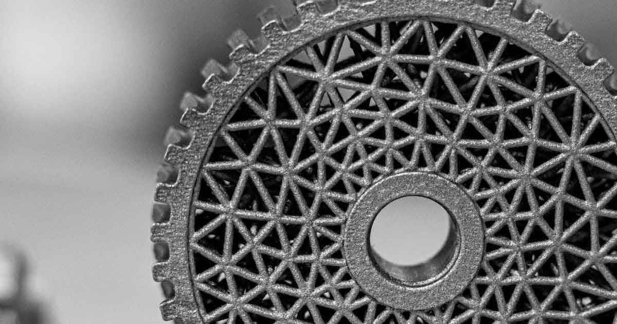 Detailaufnahme eines additiv gefertigten Metallbauteils mit komplexer Gitterstruktur und zentraler Öffnung, dargestellt in Graustufen.